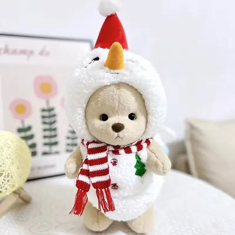 A fluffy teddy bear plush wearing a white dress and a red and white striped scarf with a pointed hat.