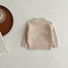 A beige knit baby pullover sweater laid flat on a light surface.