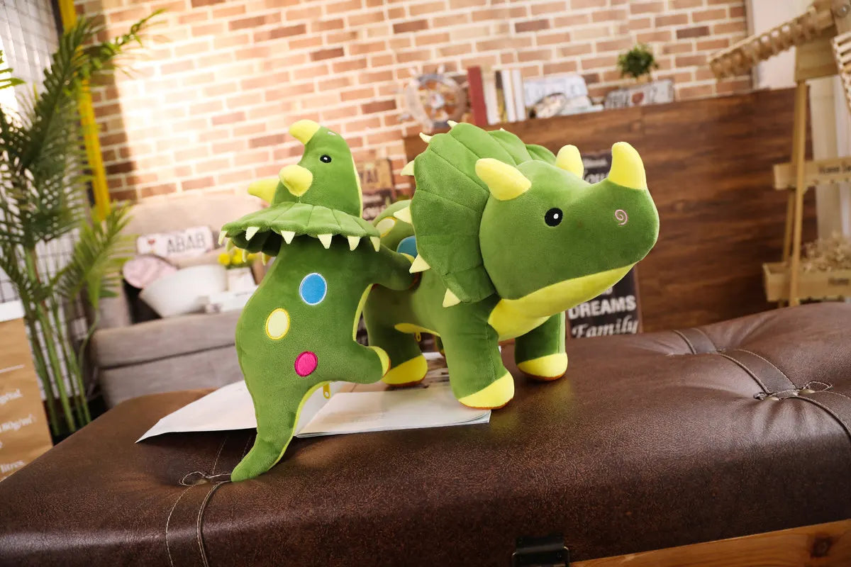 A green dinosaur plush toy with yellow accents is displayed on a brown leather surface.