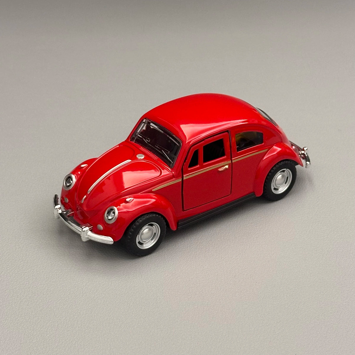 A glossy red classic retro Beetle diecast model car with chrome accents shown from the side.