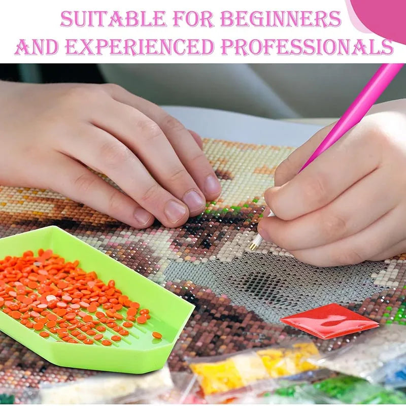Hands are using an ergonomic drill pen to paint small colored stones onto a diamond painting canvas.
