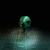 A green steel ball fidget toy with a black section, resting on a grid surface.