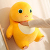 A yellow smile dinosaur plush toy is being held by a person's hand against a light background.