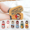 A collection of six kids cotton cartoon animal socks in various colors and designs laid out on a white surface.