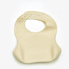 A beige soft silicone waterproof baby bib with an adjustable neck ring.