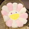 A large sunflower plush cushion with pink and white petals is displayed in a gold wire basket.