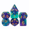 A set of seven glitter translucent polyhedral dice in various shapes and colors including a pyramid, cube, and dodecahedron.