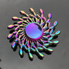 A close-up of a rainbow metal fidget spinner with a smooth, iridescent purple center and surrounding metal blades.