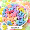 A bowl filled with pastel bear-shaped acrylic craft beads in various shades of pink, blue, yellow, and purple.