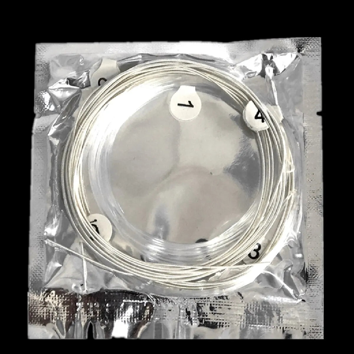 A roll of silver-plated nylon classical guitar strings packaged in clear plastic with numbered markers.