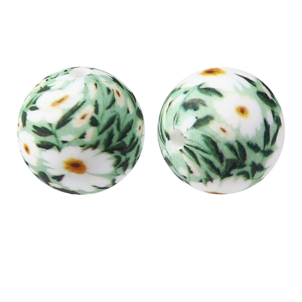 Pair of white silicone beads printed with green leaves and yellow flowers for jewelry making