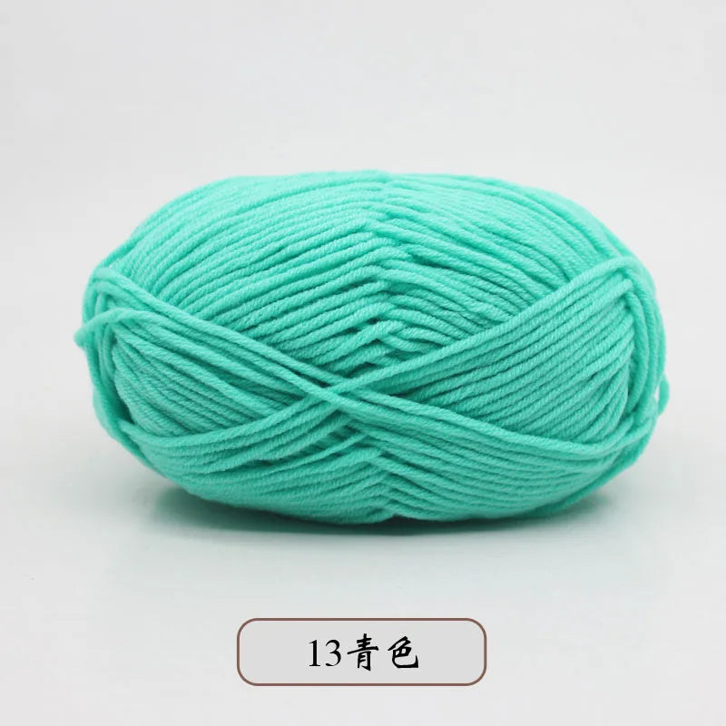A ball of teal pre-dyed milk cotton yarn used for knitting and crochet projects.