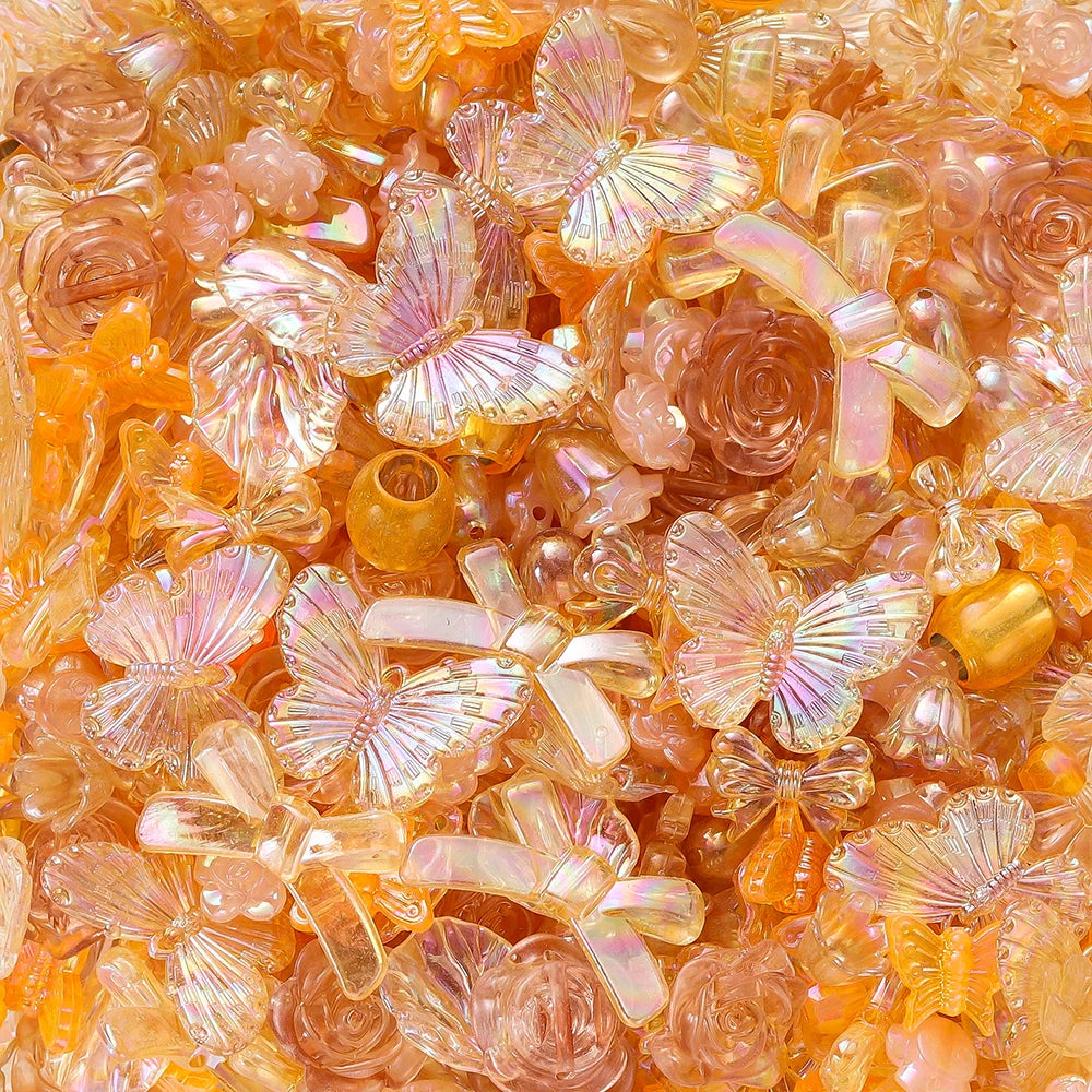 Close-up of orange and pink iridescent butterfly shell acrylic beads for DIY jewelry making
