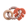 A food-grade silicone planet teether for babies in pink and orange colors.