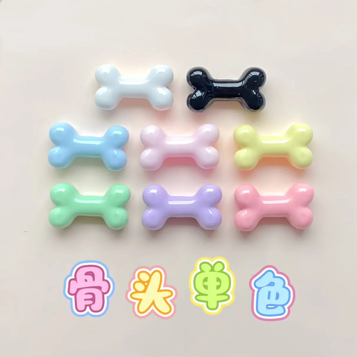 A collection of small resin bone charms in various pastel colors including blue, pink, yellow, and black.