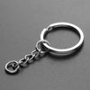Silver chain keychain featuring a circular ring and a small charm made of soft yarn.
