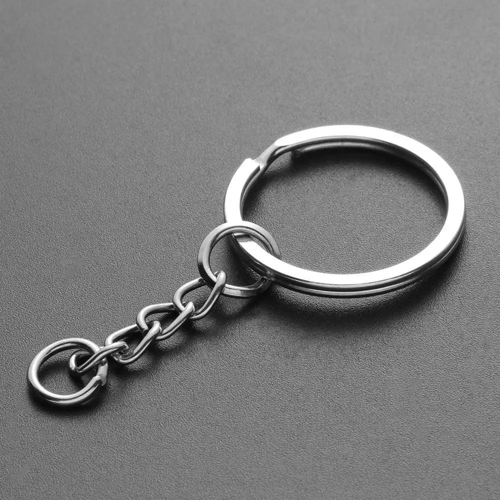 Silver chain keychain featuring a circular ring and a small charm made of soft yarn.