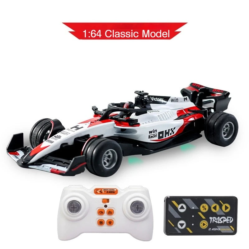 A white and red 1:64 classic model F1 remote control race car with a controller and battery.