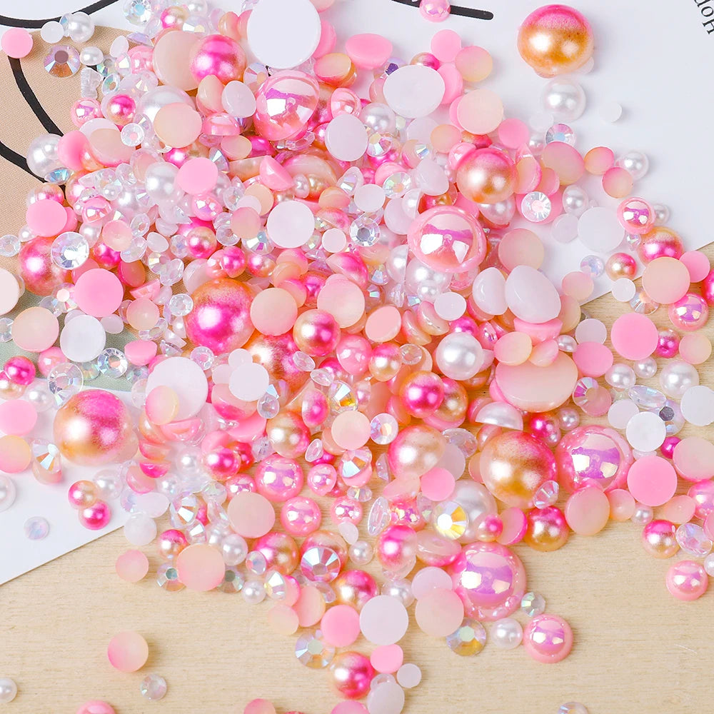 A pile of mixed resin rhinestone pearls in pink and gold finishes for crafts and nail art