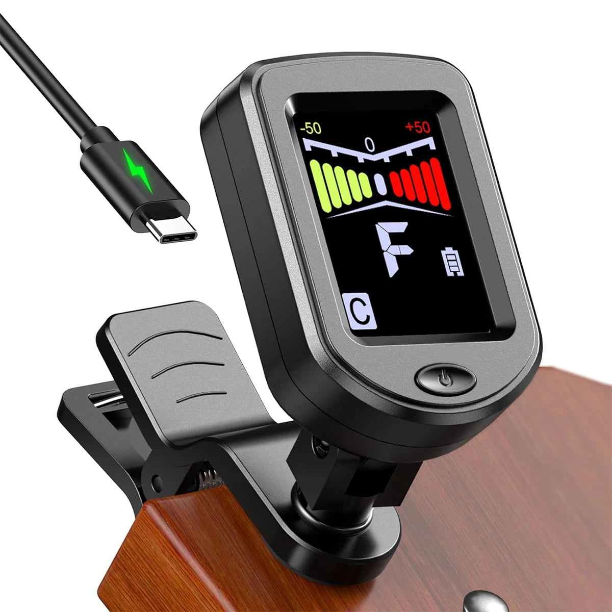 A black clip-on tuner with a color display is mounted on a wooden surface, showing tuning information.