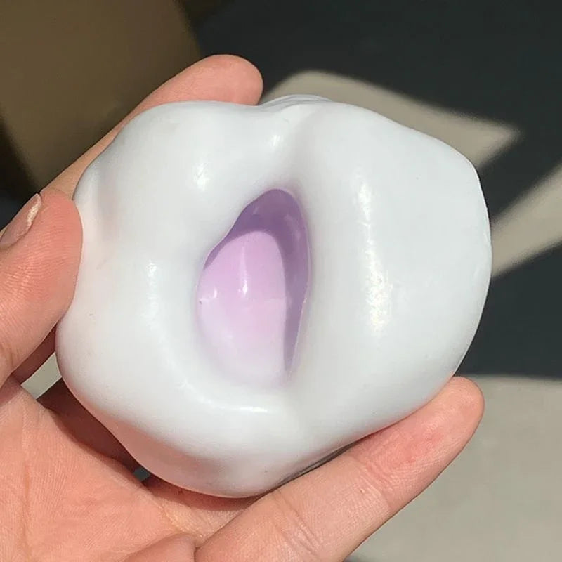 A hand holds a white, squishy stress relief ball with a translucent purple center.