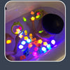 A child is playing with glow-in-the-dark animal washing water toys in a bathtub filled with glowing water.