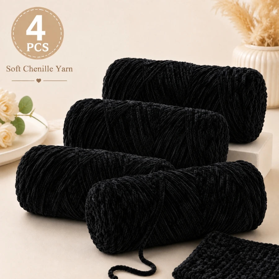 Four packs of black soft chenille yarn for crochet and knitting displayed on a light surface.