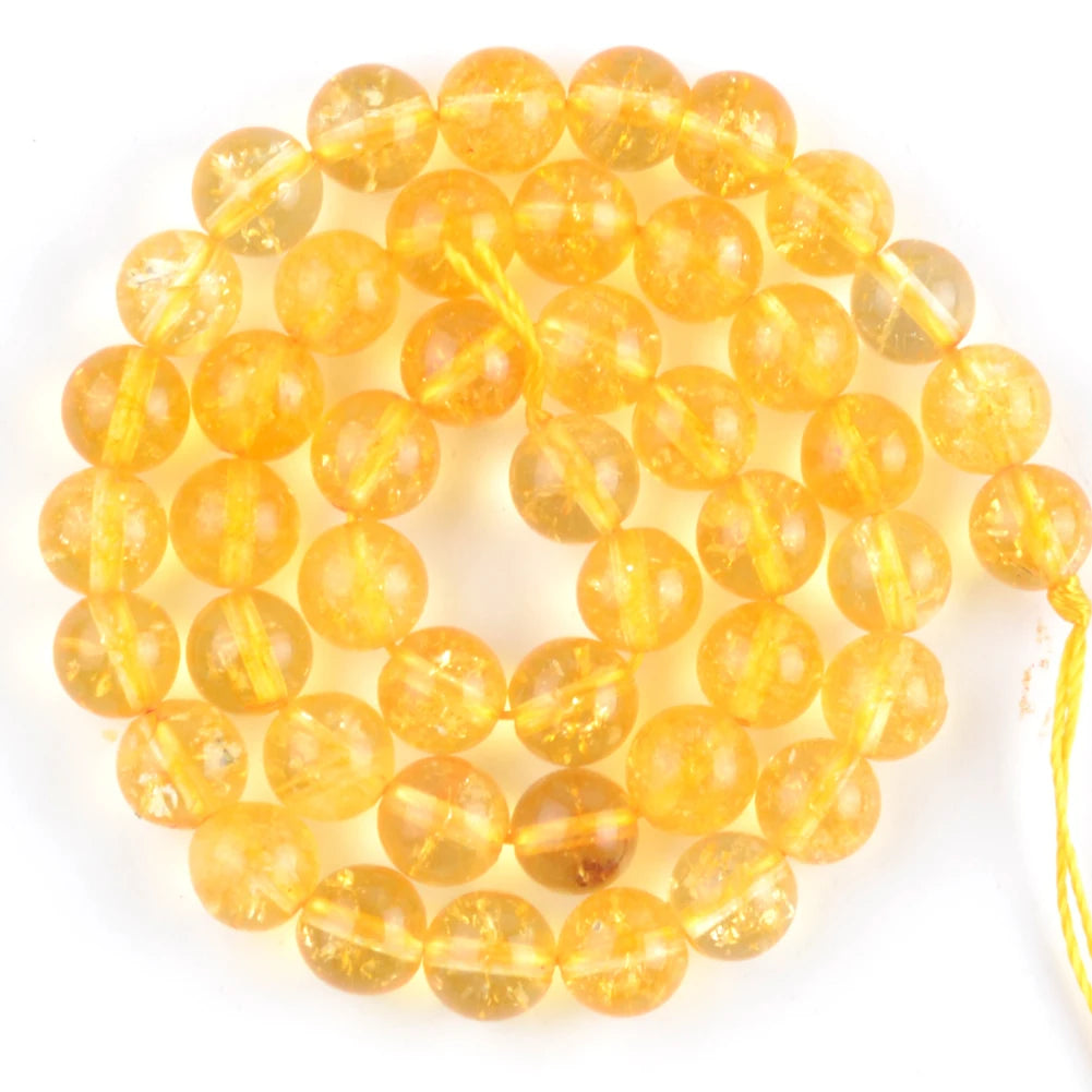 A string of small, round, translucent yellow-orange beads made from natural sea sediment jasper and turquoise for jewelry mak