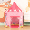 A pink pop-up play tent shaped like a rocket ship with an arched entrance and decorative floral patterns.