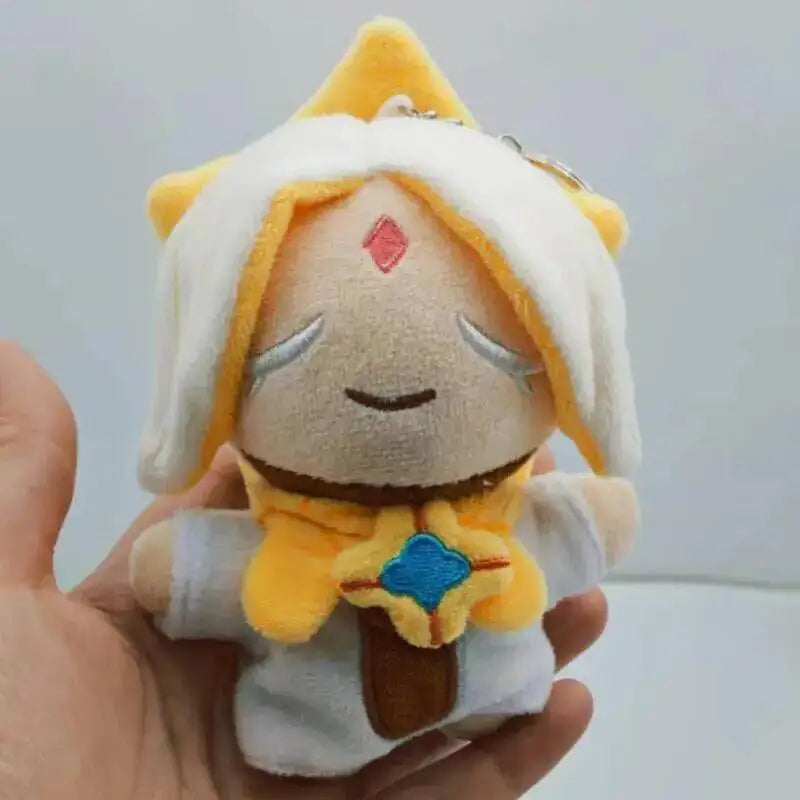 A soft yellow and white plush pendant featuring a doll-like character with a crown and facial markings.