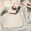 A light gray knit romper and newsboy cap set with a cream herringbone fabric detail.