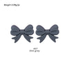 A pair of gray silicone bow tie beads used for jewelry making and craft projects.