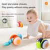 A baby is playing with a colorful musical pull-along snail toy on a white carpet.