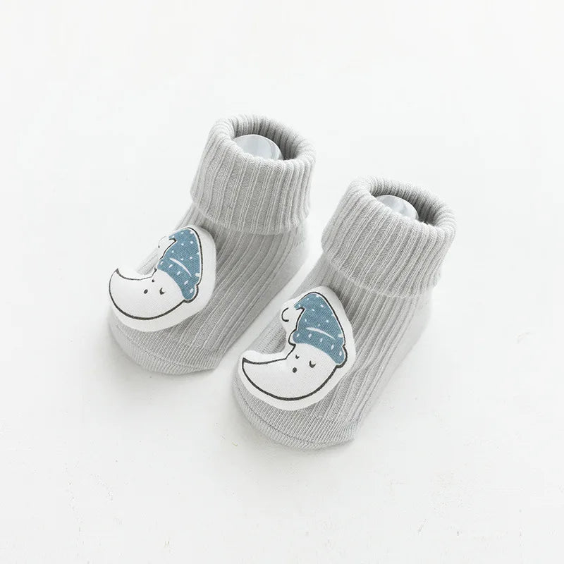 A pair of light gray cotton socks for babies featuring a cartoon sleeping face design.