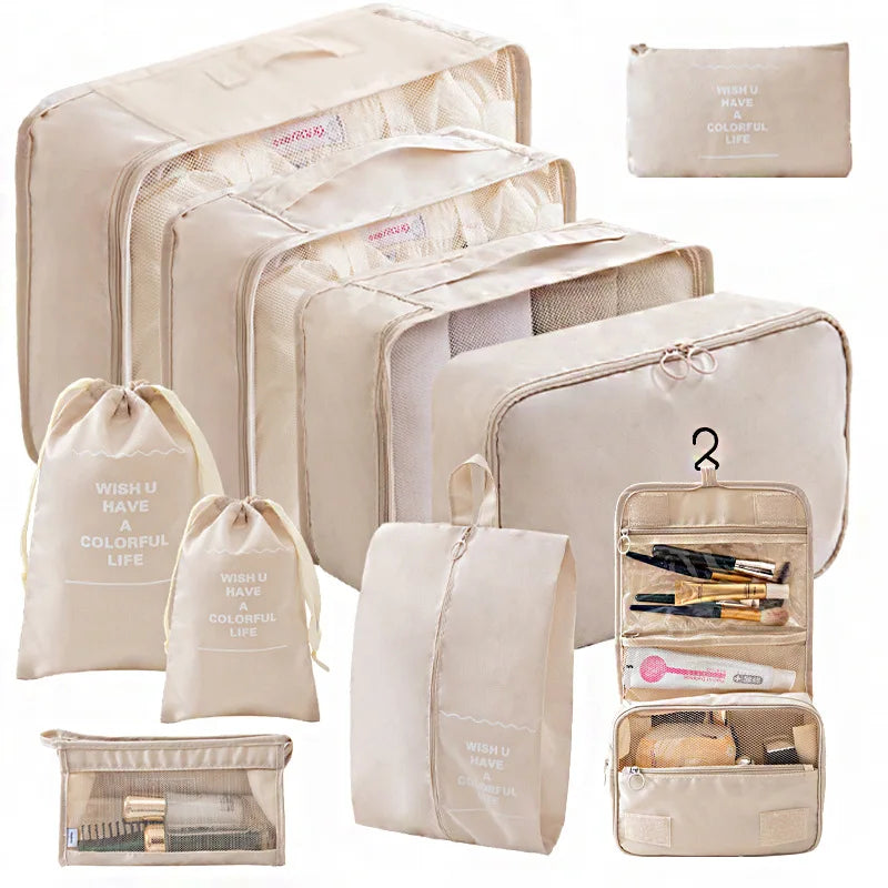 A set of beige travel packing cubes and storage bags with internal compartments.