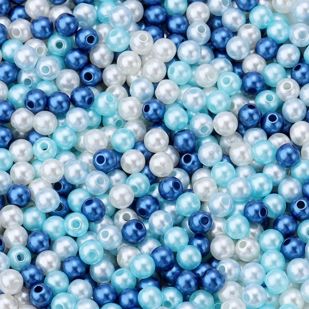 A close-up of colorful imitation pearl beads in shades of blue, white, and light blue.