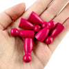 A hand holds a set of twelve wooden game pawns in six vibrant shades of pink and magenta.