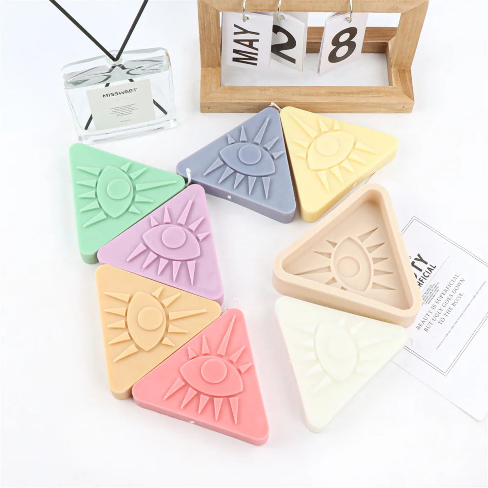 A collection of pink, green, yellow, and purple 3D evil eye silicone molds for art projects displayed on a white background.