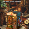 A detailed miniature wooden book nook kit featuring an ornate facade and glass windows, displayed on a rustic surface.
