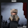 A small, fuzzy plush doll resembling a creature with large eyes and striped fabric accents stands in front of a castle silhou