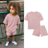 A pink kids summer tracksuit set featuring a short sleeve top and matching shorts.