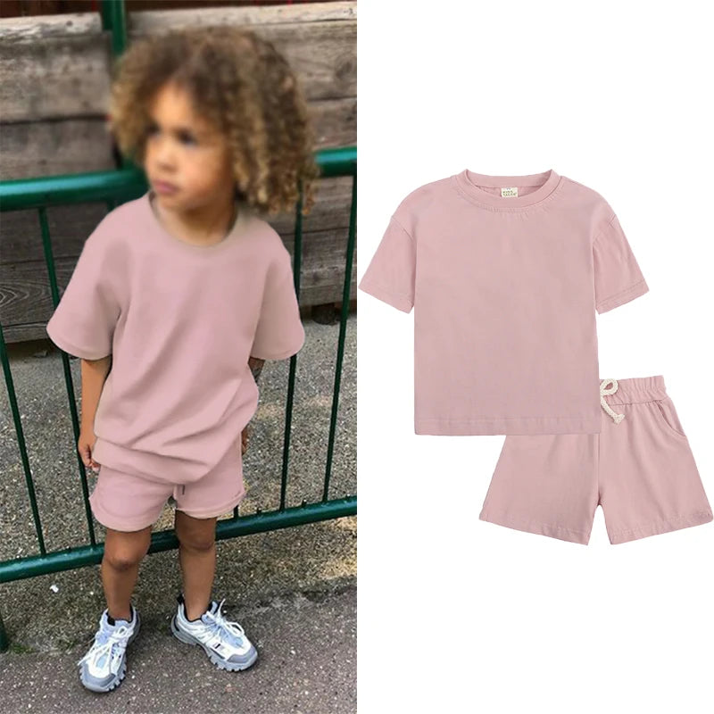 A pink kids summer tracksuit set featuring a short sleeve top and matching shorts.