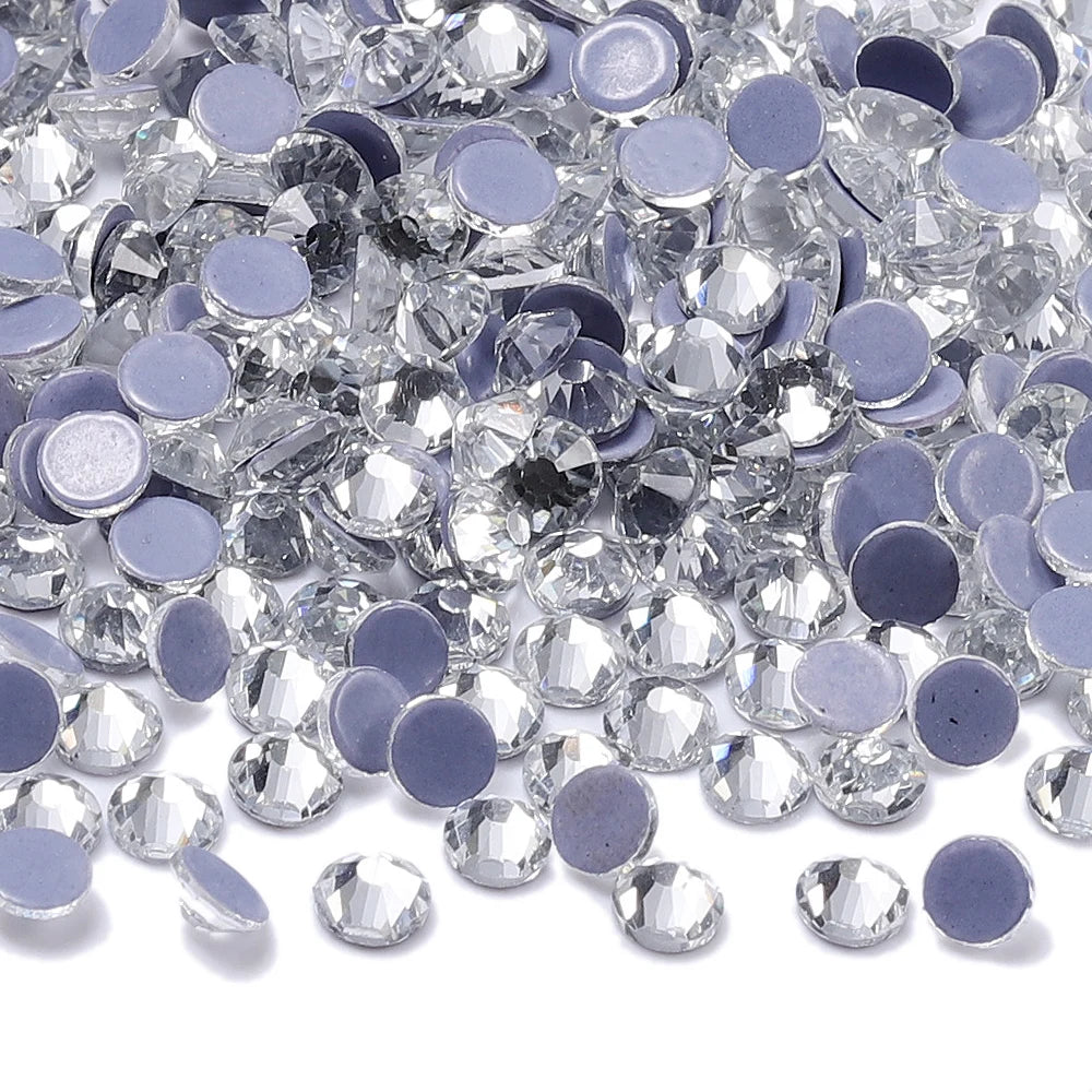 A pile of clear and purple glass crystal rhinestones for DIY crafts and decor