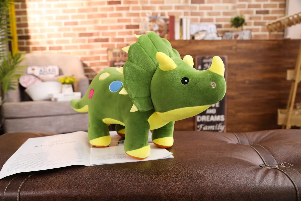 A green dinosaur plush toy with yellow accents sits on a brown leather couch.