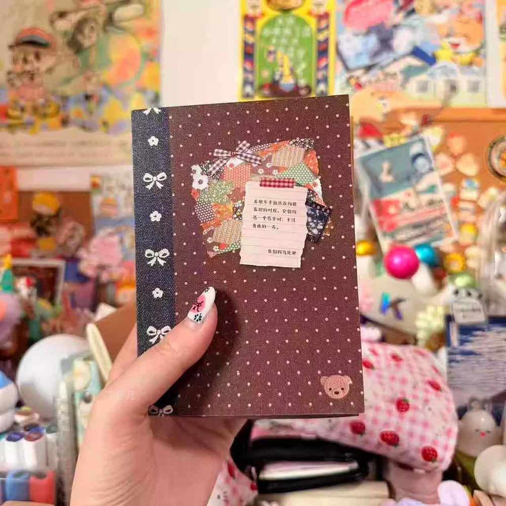 A hand holds a brown sticker book with a dark purple ribbon, featuring retro designs and colorful stickers.
