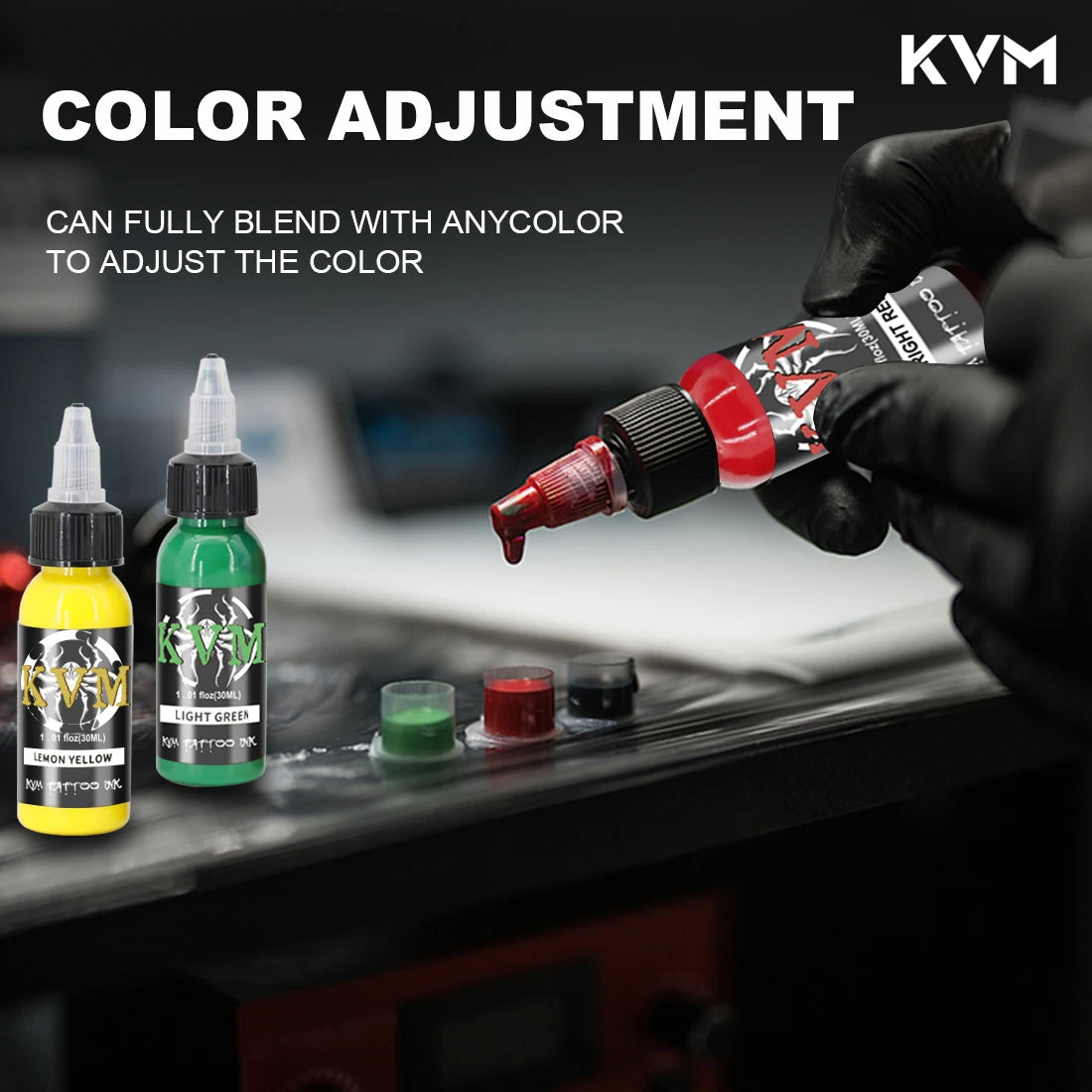 A hand adjusts a tattoo color using an ink dropper, with various colored inks and bottles visible on a dark surface.