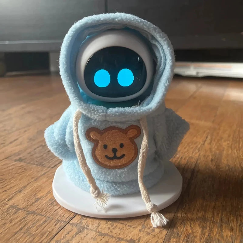 A plush toy resembling a bear wearing a light blue hooded garment with glowing blue eyes