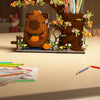A terracotta building block capybara figurine with foliage and an orange pumpkin, used as a desk organizer.