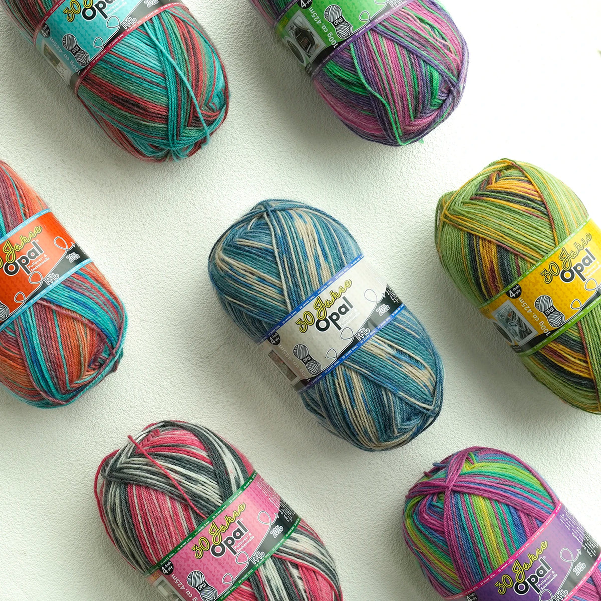 A collection of colorful Opal 4-ply sock yarn balls in various shades and textures.
