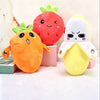 Three plush toys shaped like a strawberry, a carrot, and a banana with faces.